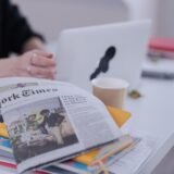 Laptop pe o masă de acasă, pregătit pentru o consultație medicală online, lângă un tensiometru și câteva analize