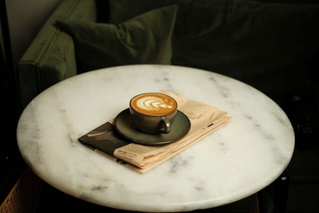 Ziar deschis la pagina de sănătate, pe o masă de cafea, lângă o ceașcă și o pereche de ochelari