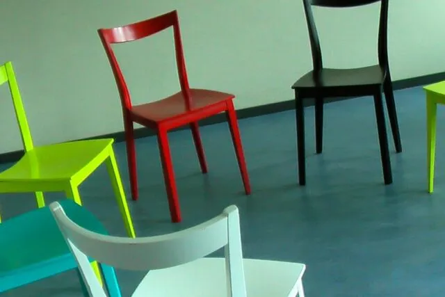 Sală de așteptare cu scaune goale și o plantă, într-o clinică modernă