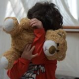 Școlar care merge spre școală cu ghiozdanul purtat corect pe ambii umeri, văzut din spate